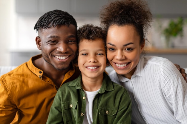 Photo une famille noire heureuse avec un enfant souriant ensemble à la maison.