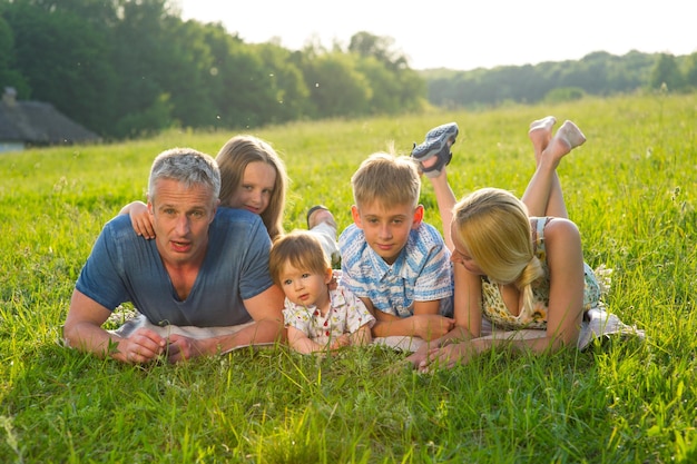 Famille nombreuse sur un pré vert.