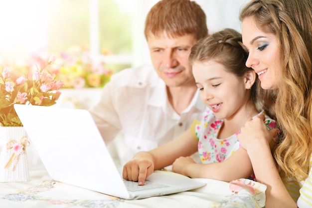 Famille avec ordinateur portable à la maison