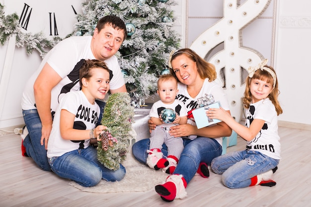 Famille ouverture des cadeaux de Noël à la maison ensemble.