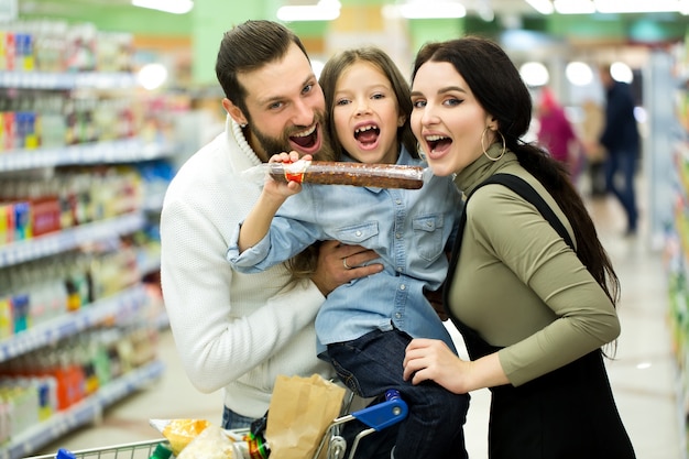 Famille avec panier avec nourriture visite supermarché