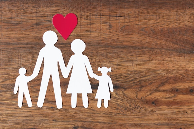 Famille de papier heureux avec coeur sur la vue de dessus de fond en bois foncé