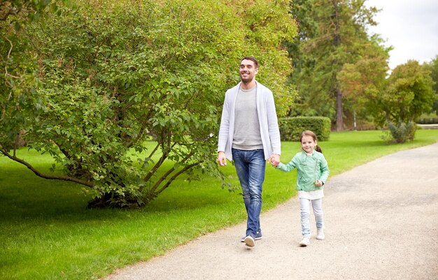 famille, parentalité, paternité, adoption et concept de personnes - père heureux et petite fille marchant dans le parc d'été