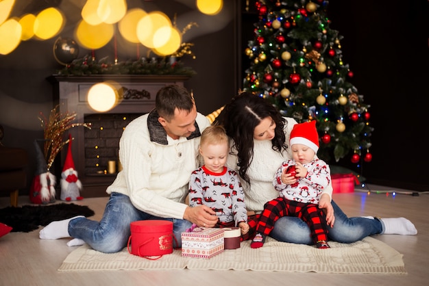 Famille. Parents et enfants en costumes de Noël, pyjamas avec décorations de Noël