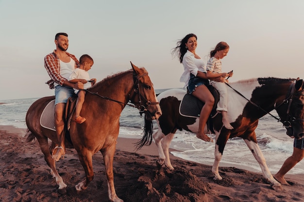 La famille passe du temps avec ses enfants tout en faisant de l'équitation ensemble sur une plage de sable. Mise au point sélective. Photo de haute qualité