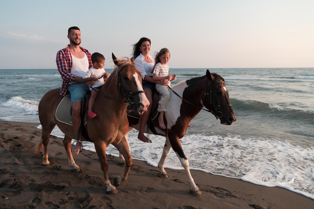 La famille passe du temps avec ses enfants tout en faisant de l'équitation ensemble sur une plage de sable. Mise au point sélective. Photo de haute qualité