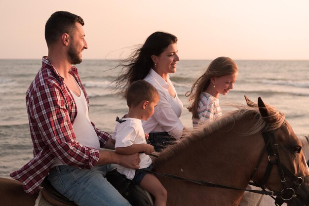 La famille passe du temps avec ses enfants tout en faisant de l'équitation ensemble sur une plage de sable. Mise au point sélective. Photo de haute qualité