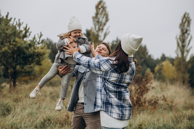 Famille avec petite fille ensemble par temps d'automne s'amusant