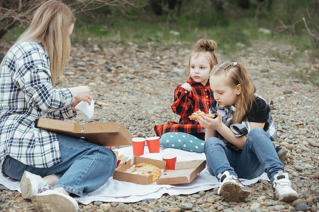 famille en pique-nique à l'extérieur de la ville, mère et deux petites filles