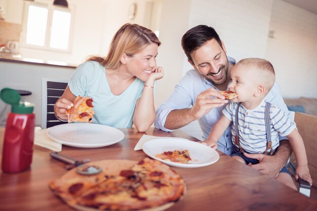 Famille avec pizza dans la cuisine