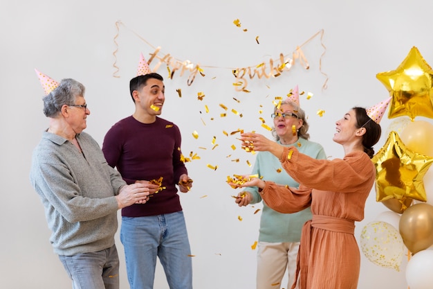 Famille de plan moyen célébrant avec des confettis