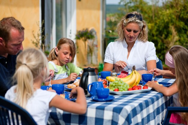 Famille prenant un café dans le jardin