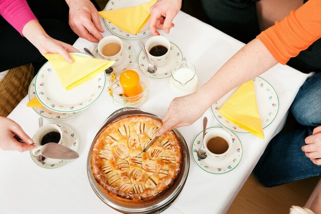 Famille prenant un café et un gâteau ensemble