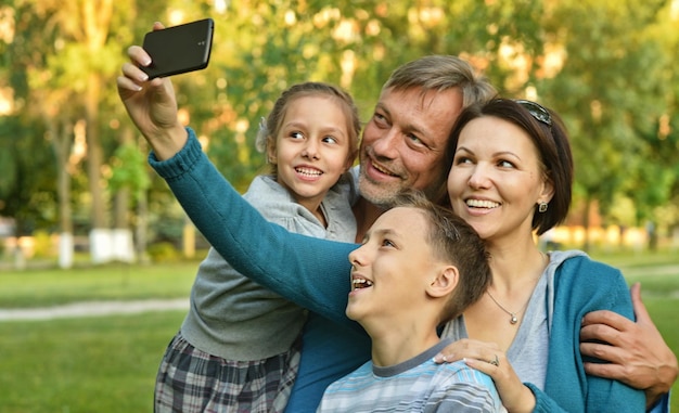 Photo famille prenant selfie dans le parc
