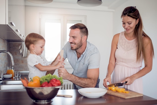 Famille préparant le repas avec le fils