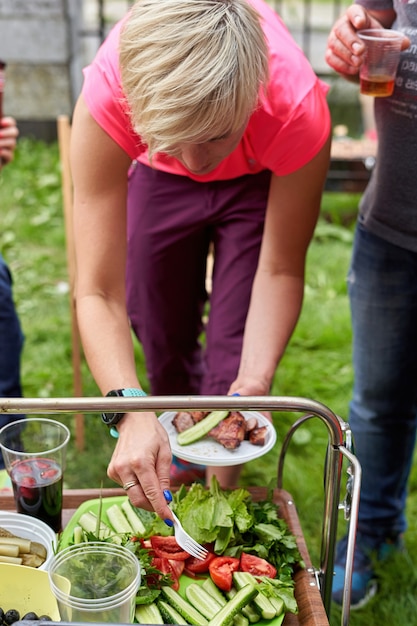 Photo la famille prépare de la viande et des légumes pour un pique-nique dans le jardin