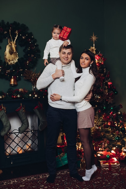 Famille en présente à côté de l'arbre de Noël.