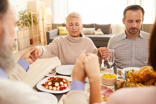 Famille priant avant le dîner