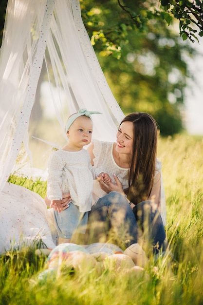 Famille profitant de la vie ensemble dans le parc d'été. Heureuse jeune famille à l'extérieur.