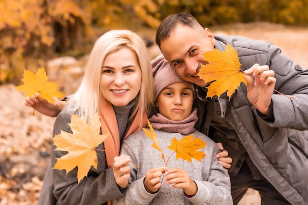 Une famille de quatre personnes profitant de feuilles d'or dans le parc d'automne