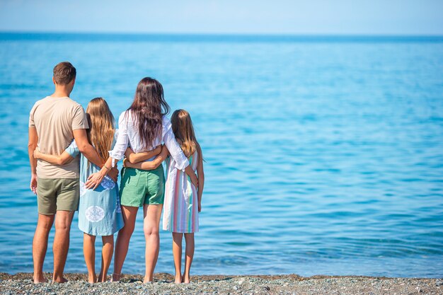Une famille de quatre personnes s'amuse ensemble pendant les vacances à la plage