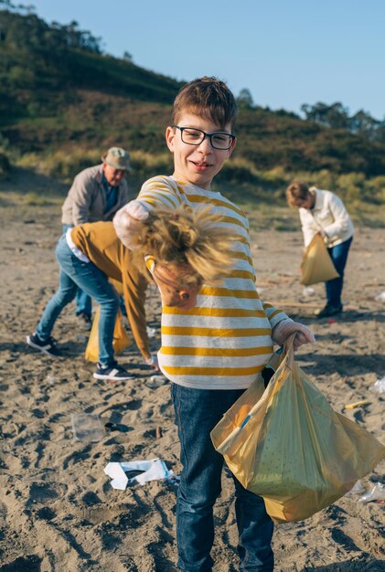 Photo une famille ramasse les ordures en nettoyant la plage.