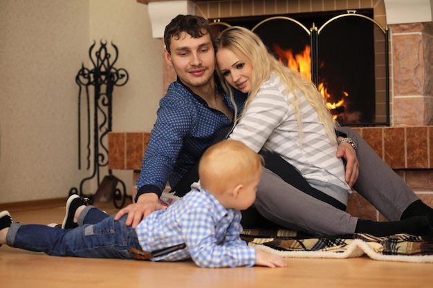 Famille réchauffée par la cheminée assise sur le canapé à la maison