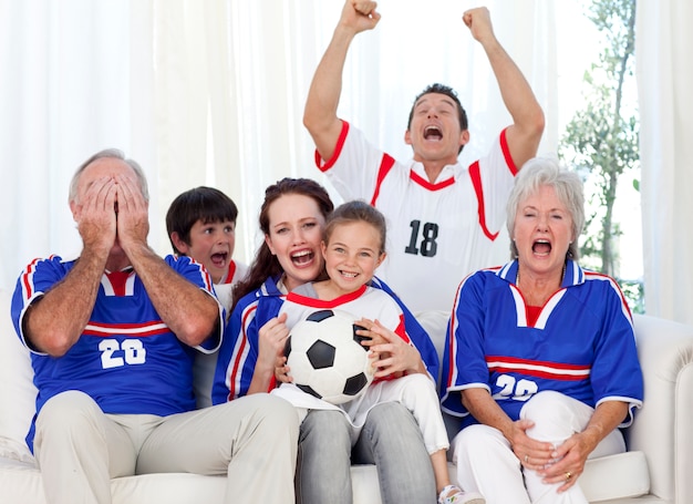 Famille regardant un match de football à la télévision