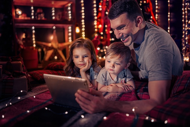 Famille regardant une vidéo amusante sur une tablette numérique famille noël noël technologie et concept de personnes