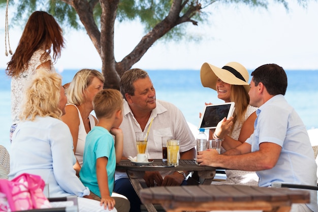 Famille, regarder, photo, sur, tablette tactile, dans, café extérieur