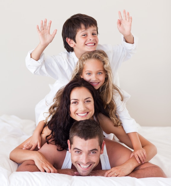 Famille s&#39;amuser au lit avec les mains