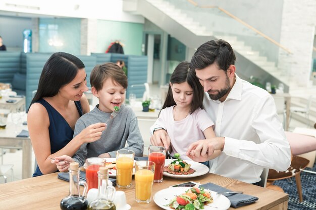 Famille s'asseyant ensemble dans le concept de déjeuner de restaurant