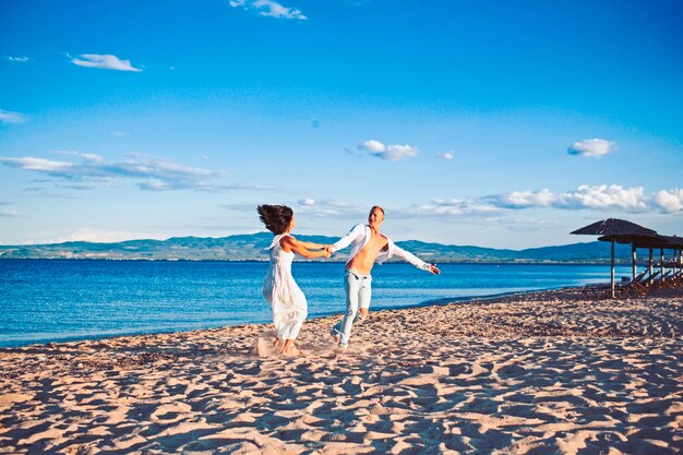 Famille et Saint Valentin. Vacances d'été et vacances de voyage. Femme et homme sexy en mer. Couple amoureux danse sur la plage. Relations amoureuses du couple dansant profitant de la journée d'été ensemble.