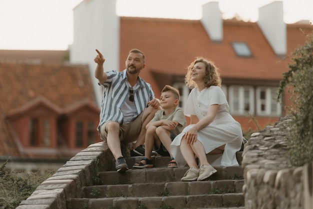 Une famille se détend sur les escaliers entre les toits d'une vieille ville européenne