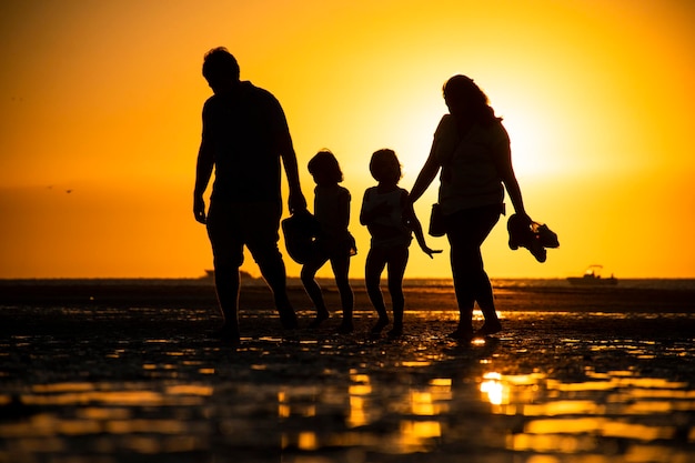 Photo famille se promenant sur la plage