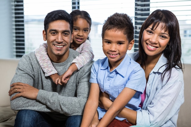 Famille souriante sur le canapé