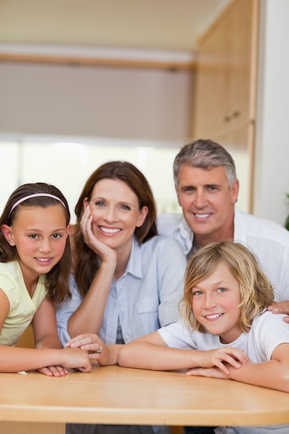 Famille souriante derrière la table de la cuisine