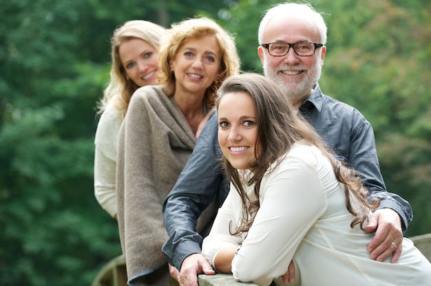 Famille souriante heureuse ensemble à l&#39;extérieur