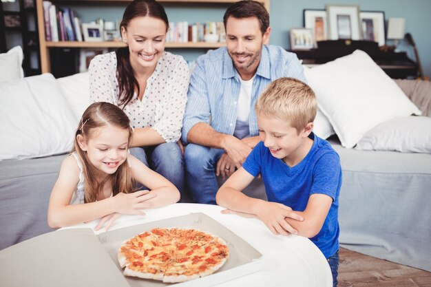 Famille souriante avec pizza sur table