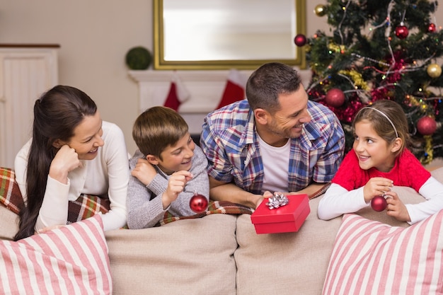 Famille souriante, s&#39;appuyant sur le canapé