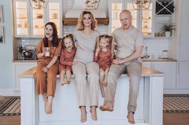 Famille suédoise assise sur la table de la cuisine le dimanche matin prenant son petit déjeuner ensemble