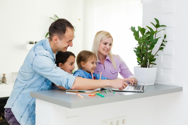 Famille travaillant à l'ordinateur portable avec au bureau à domicile