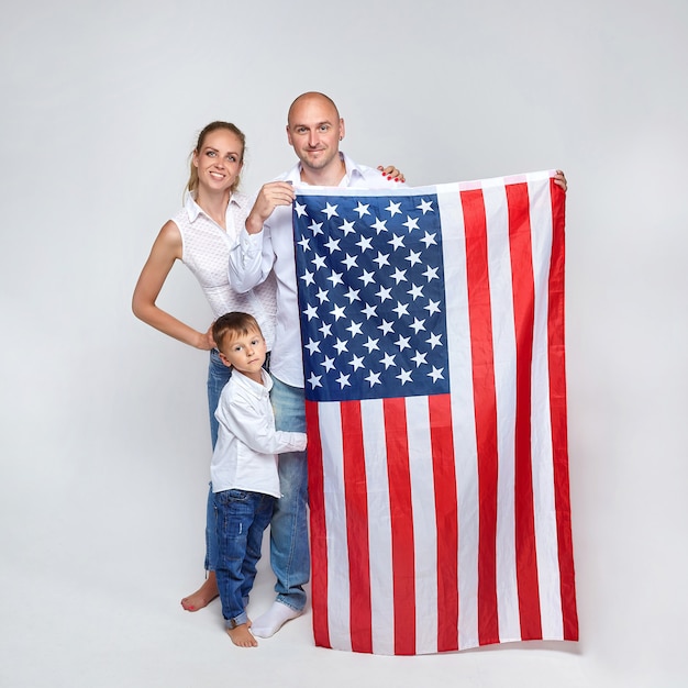 une famille de trois avec un drapeau américain sur fond blanc