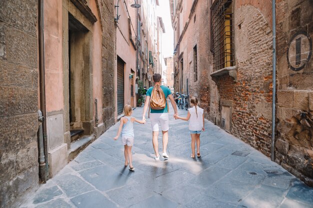 Famille de trois personnes marchant dans une rue vide