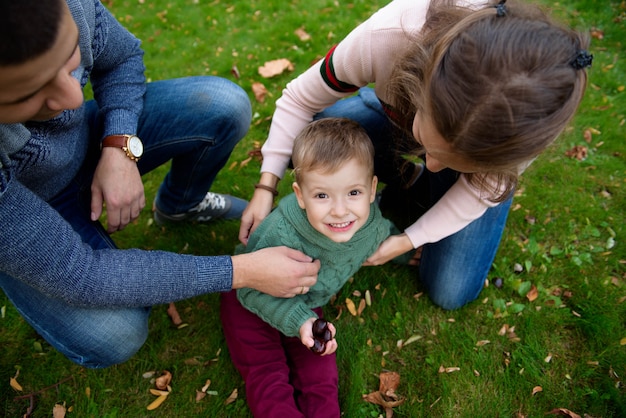 Famille de trois personnes profiter d'un parc en automne s'amuser sourire