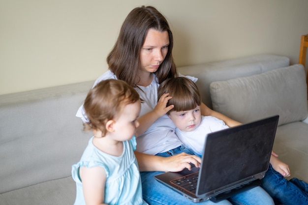 Famille de trois personnes utilisant une caméra d'appel vidéo pour ordinateur portable