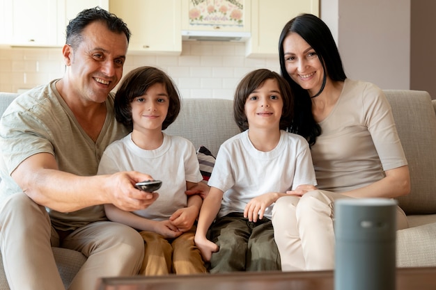 Photo famille utilisant un haut-parleur intelligent à la maison