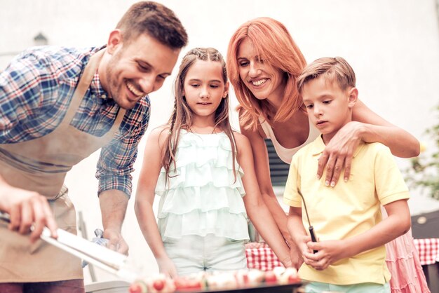 Famille en vacances ayant un barbecue