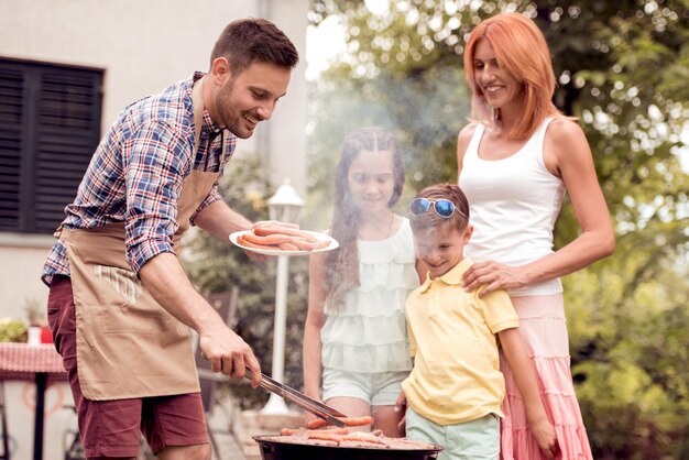 Photo famille en vacances ayant un barbecue