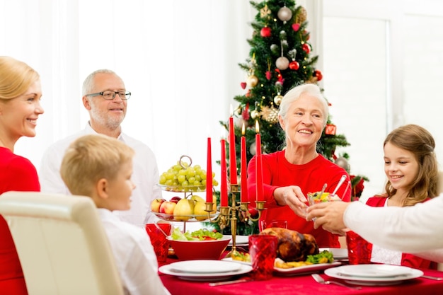 famille, vacances, génération, noël et concept de personnes - famille souriante en train de dîner à la maison